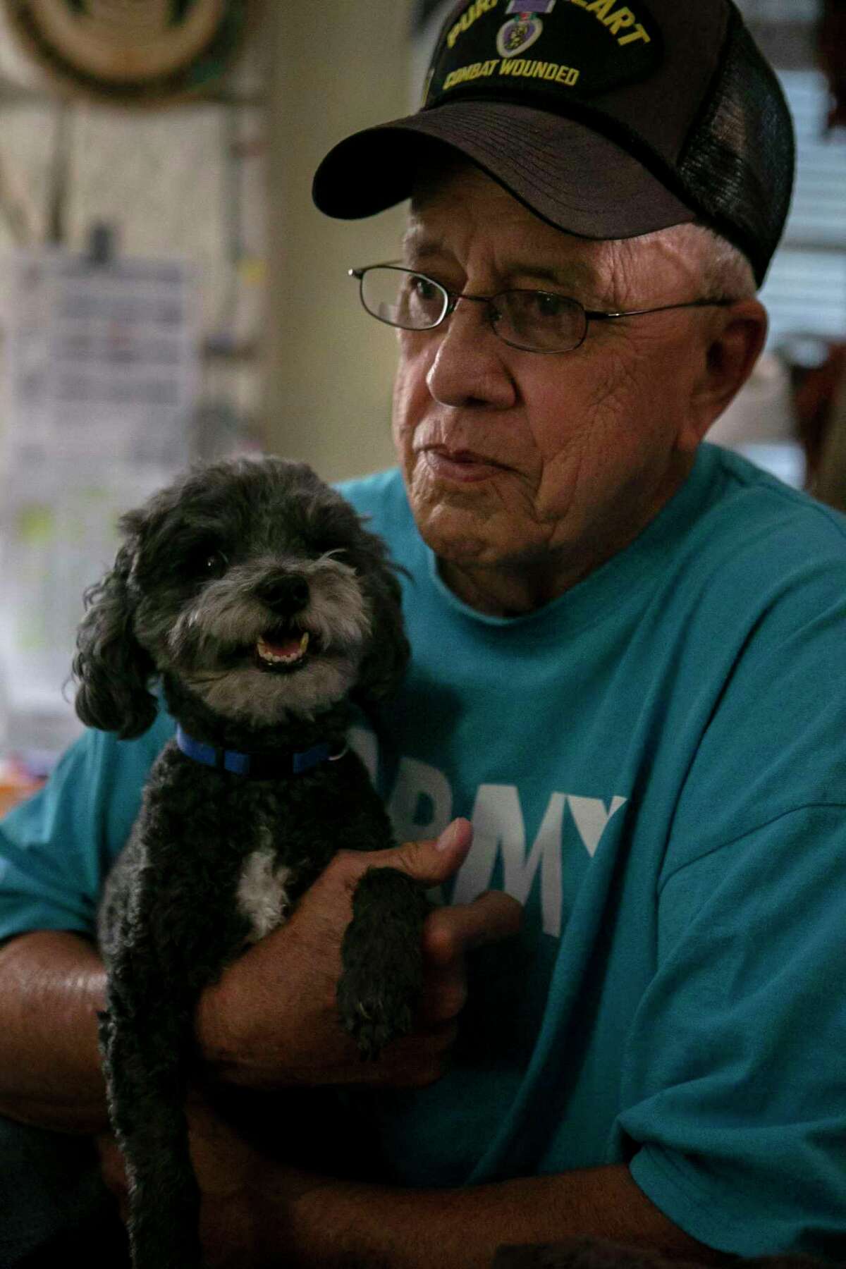 Retired Army Sgt, Maj. Fred Navarro holds his service dog of eight years in his San Antonio, Texas home on Sept. 19, 2019. Navarro has suffered from PTSD and nightmares since the battle he survived on April 11, 1966.