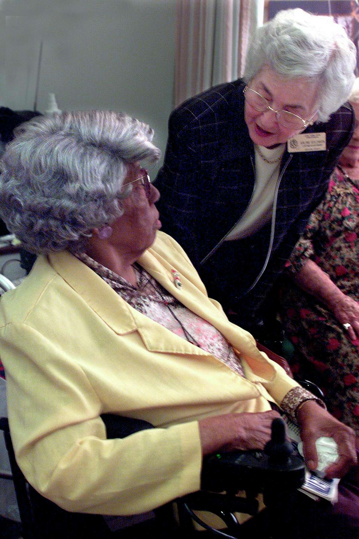 Arline Solomon, right, who volunteers with a Long Term Care Ombudsman Program, speaks with a resident of a long-term care facility in Oxnard, California. The Long Term Care Ombudsman Program got its start in 1972. Today, there is an ombudsman program operating in every state across the U.S. (Photo by Anne Cusack/Los Angeles Times via Getty Images)
