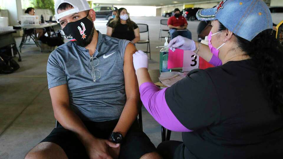 Nick Ramos, 33, gets a Covid-19 vaccination from Nurse Mary Calderon at a pop-up clinic at the San Antonio Zoo on Tuesday, July 20, 2021. The zoo partnered with San Antonio Metropolitan Health District to provide the public with COVID-19 vaccinations. As an incentive, the zoo gave free tickets to their Dragon Forest exhibit to everyone who received the vaccine during the event.