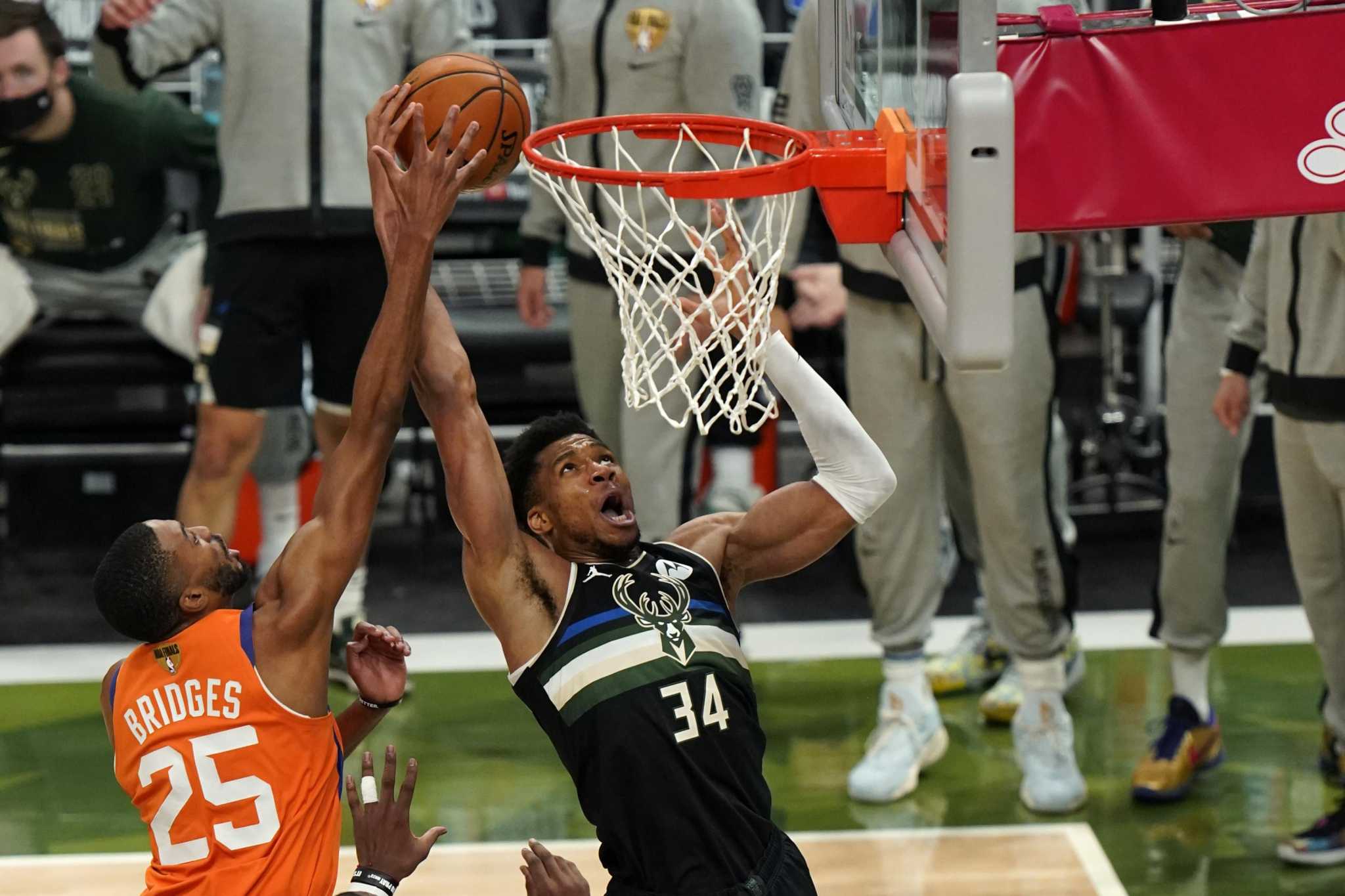 FILE - In this July 20, 2021, file photo, Milwaukee Bucks forward Giannis  Antetokounmpo holds the NBA Championship trophy, left, and Most Valuable  Player trophy after defeating the Phoenix Suns in Game