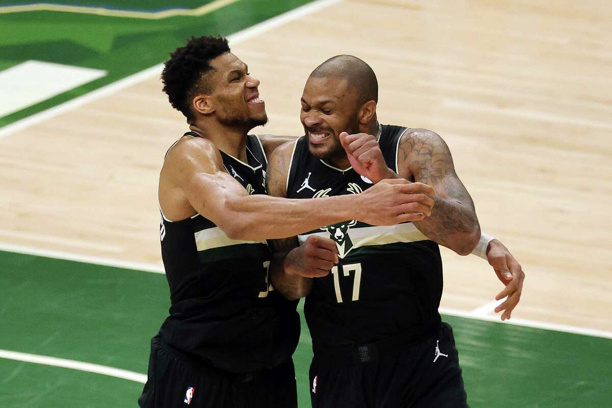 MILWAUKEE, WISCONSIN - JULY 20: Giannis Antetokounmpo #34 of the Milwaukee Bucks celebrates with teammate P.J. Tucker #17 in the final seconds before defeating the Phoenix Suns in Game Six to win the 2021 NBA Finals at Fiserv Forum on July 20, 2021 in Milwaukee, Wisconsin. NOTE TO USER: User expressly acknowledges and agrees that, by downloading and or using this photograph, User is consenting to the terms and conditions of the Getty Images License Agreement.