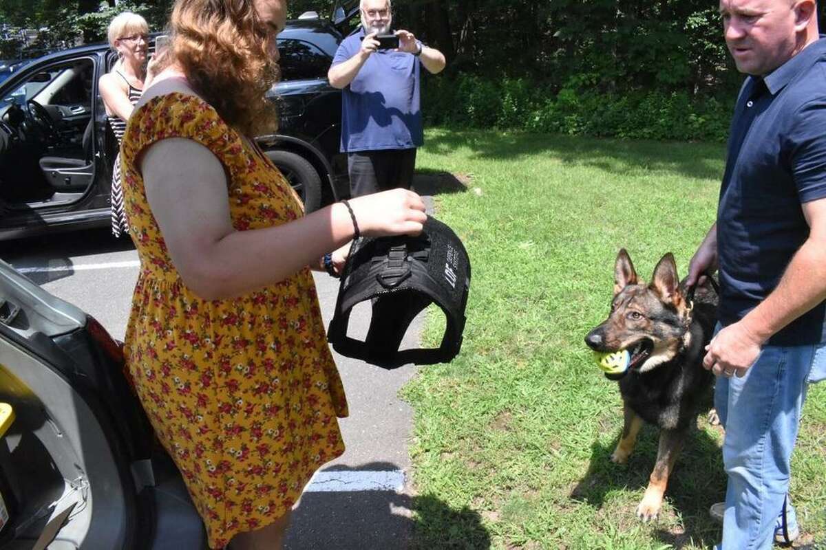 Brittany Murphy of West Haven, left, raised money to donate a life-saving bulletproof vest to Portland Police K-9 Magnus, whose handler, Sgt. Jim Kelly, right, was thrilled.