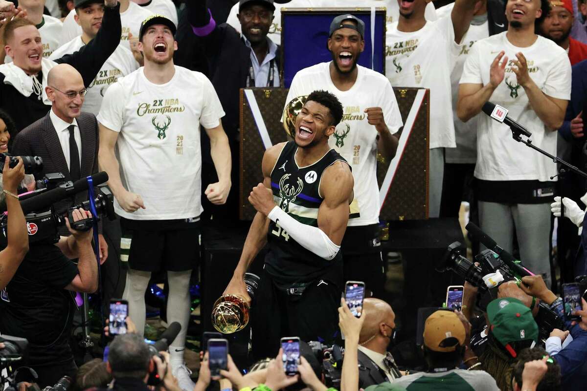 FILE - In this July 20, 2021, file photo, Milwaukee Bucks forward Giannis  Antetokounmpo holds the NBA Championship trophy, left, and Most Valuable  Player trophy after defeating the Phoenix Suns in Game