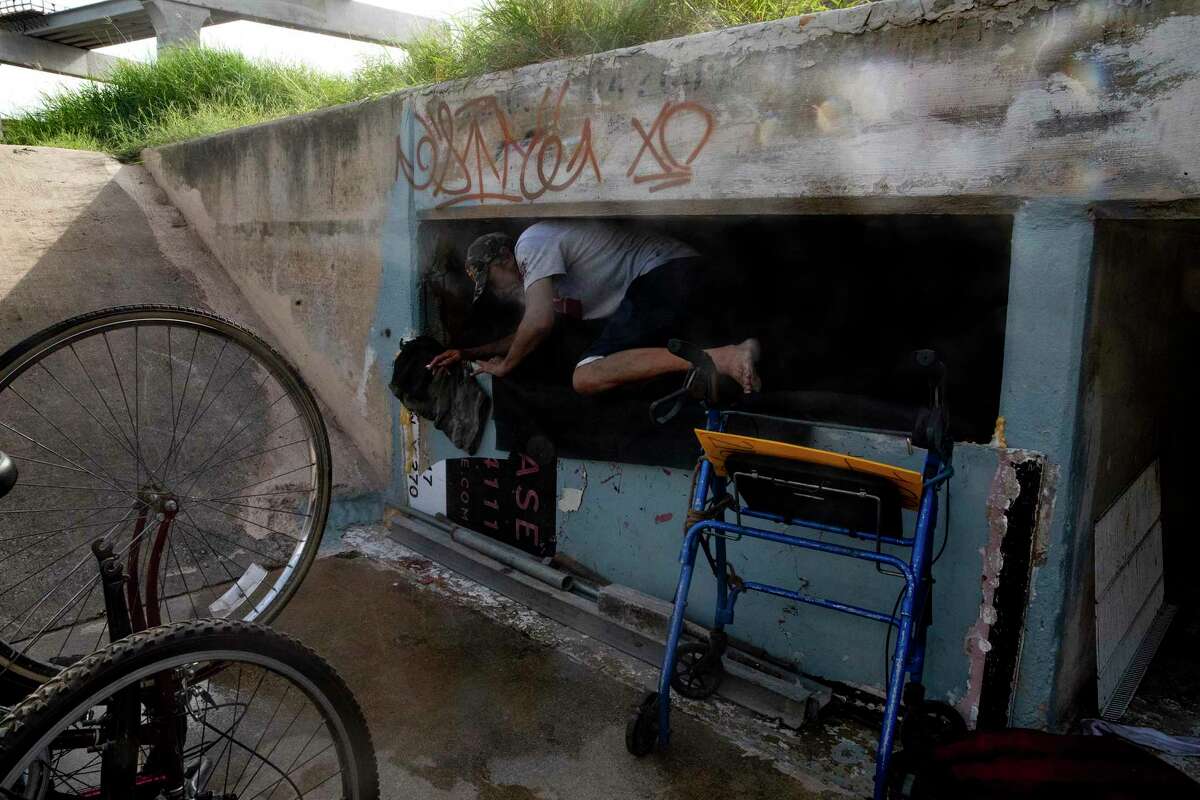 Mike Stevens climbs over a makeshift wall and into a drainage tunnel where he has made his home. Stevens lost all his possessions during a recent heavy rain. Luckily, he was not in the tunnel during the storm.