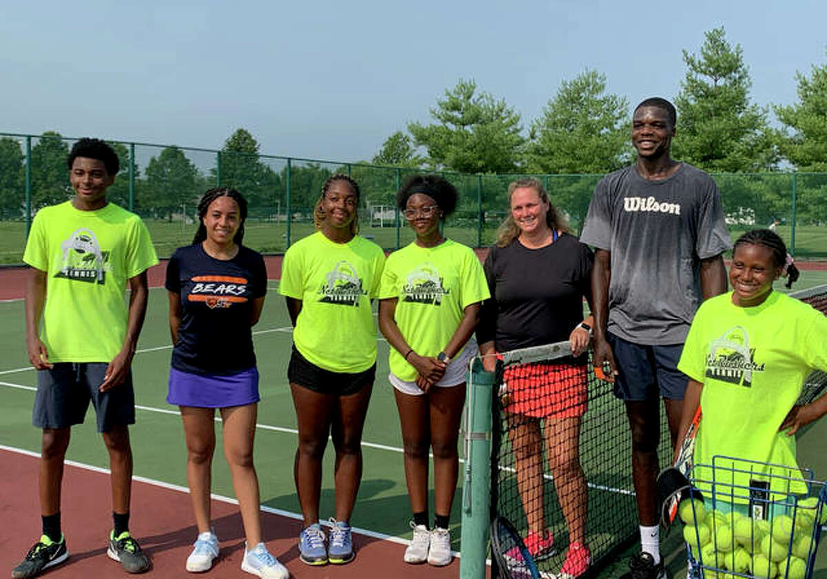 Members of Net Rushers pose with Kweisi Kenyatte on one of the tennis courts at Liberty Middle School.