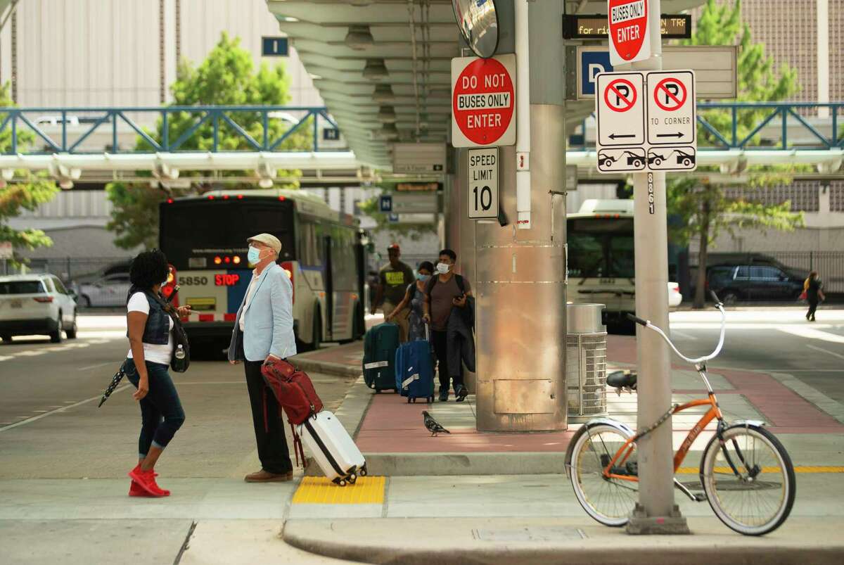 Passengers navigate outside Metropolitan Transit Authority’s downtown transit center on July 20, 2021, in downtown Houston. Metro’s 1,200-bus fleet currently has zero electric vehicles.