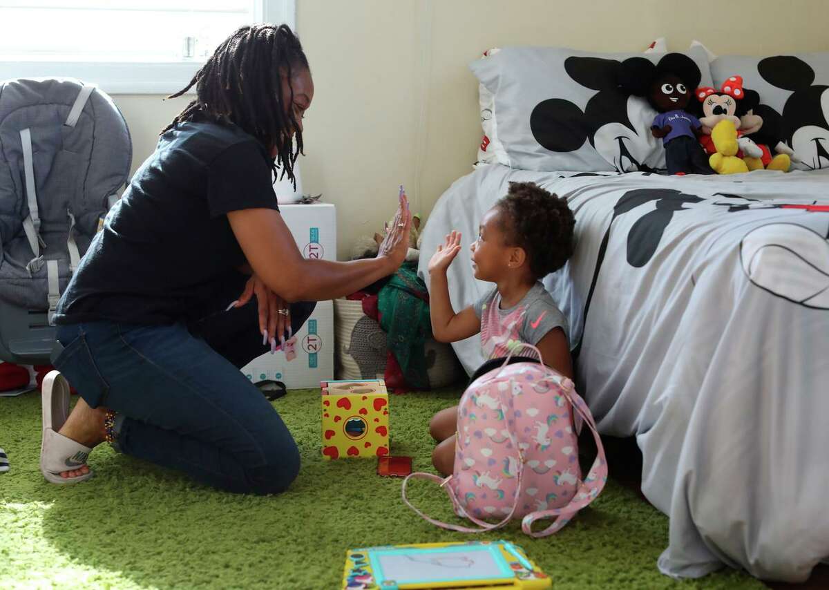 Sharayah Alexander high-fives daughter Savannah, 2, in their Vallejo home. Alexander is involved in the Deliver Birth Justice campaign to reduce Black maternal and infant mortality.