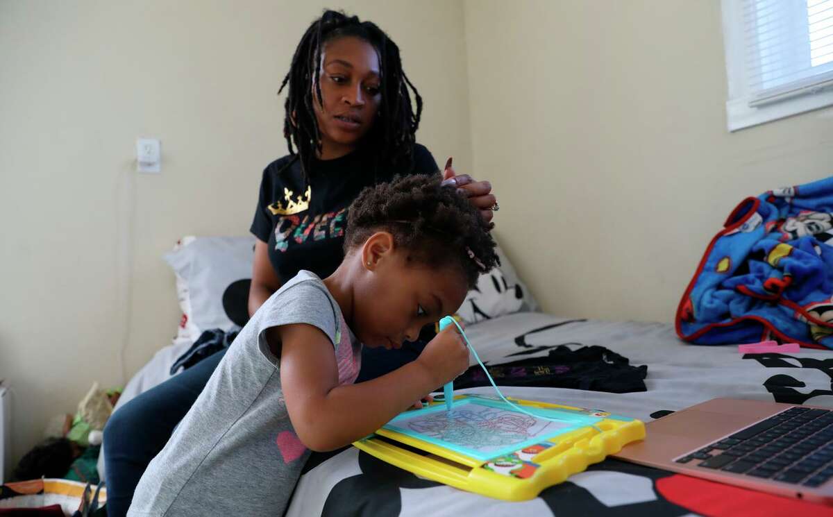 Sharayah Alexander, 32, shown with 2-year-old Savannah, attends a webinar on scholarships for entrepreneurs. Alexander is involved in the Deliver Birth Justice campaign to reduce Black maternal and infant mortality.
