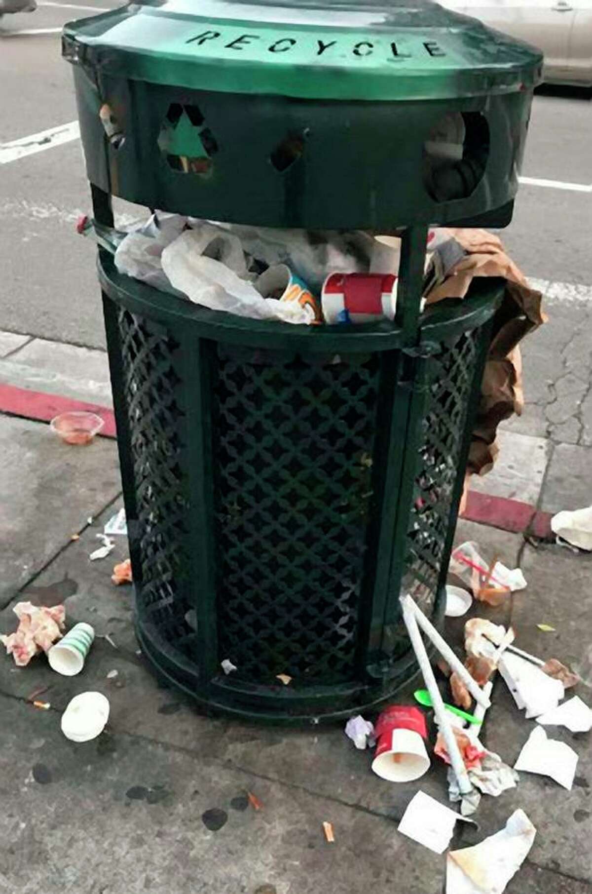 A trash overflows on a San Francisco sidewalk.