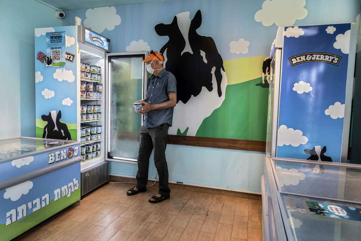 FILE - In this Tuesday, July 20, 2021 file photo, an Israeli shops at the Ben & Jerry's ice-cream factory in the Be'er Tuvia Industrial area, southern Israel. Alan Jope the CEO of Unilever on Thursday, July 22, 2021, said the global consumer goods giant remains "fully committed" to doing business in Israel, distancing himself from this week's announcement by the company's Ben & Jerry's ice cream brand to stop serving Israel's West Bank settlements. Jope gave no indication that Unilever would force Ben & Jerry's to roll back its controversial decision. (AP Photo/Tsafrir Abayov, File)