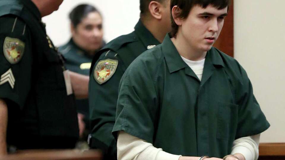 FILE - In this Feb. 25, 2019, file photo Dimitrios Pagourtzis, the former Santa Fe High School teenage student accused of killing 10 people in a May 2018 shooting at the high school, is escorted by Galveston County Sheriff's Office deputies into the jury assembly room for a change of venue hearing at the Galveston County Courthouse in Galveston, Texas. Pagourtzis remains in a mental health facility, deemed incompetent so far to stand trial on capital murder charges.