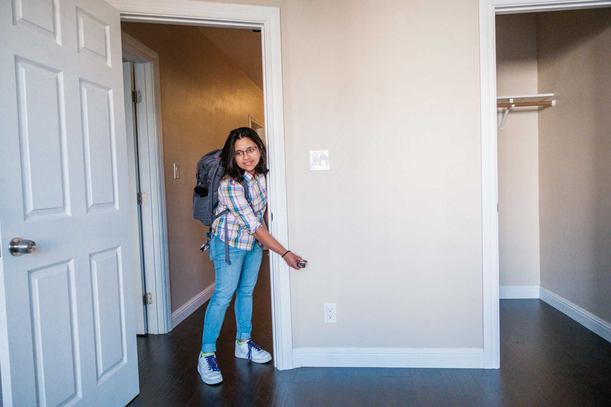 Anusha Datar, who recently moved to San Francisco from Boston, uses a device to measure the size of a room during an open house walk through in San Fr