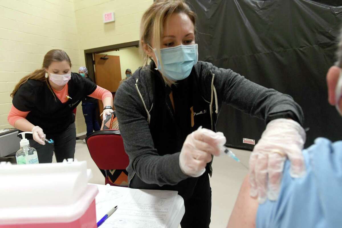 Kaci Griffin (left) and Liz Powell with Aurora Concepts administer a first doses of the Moderna vaccine during Hardin County's Monday morning COVID-19 vaccine clinic in Lumberton. The county is holding clinics as vaccine becomes available and trying to reach residents throughout the county by staging them at different locations. Photo taken Monday, February 8, 2021 Kim Brent/The Enterprise