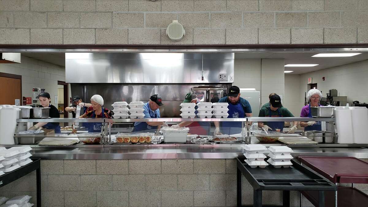 FILE - Volunteers from the United Way of Midland County, the Great Lakes Loons and Isabella Bank spent the morning of Wednesday, July 21, 2021 preparing and serving meals with Hidden Harvest and East Side Soup Kitchen in Saginaw. 