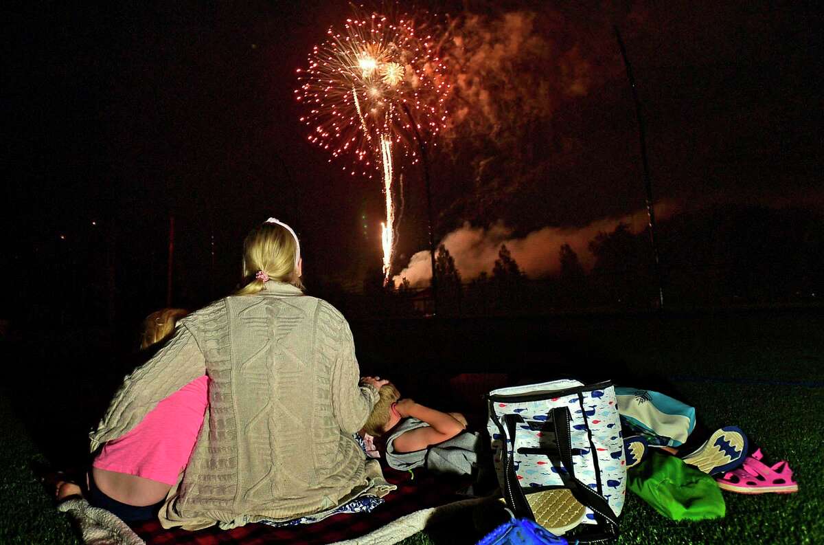 The Lafreniere family enjoy the Darien 2021 Fireworks Display at Darien High School Thursday, July 23, 2021, in Darien, Conn. Last year's display was cancelled due to the pandemic.