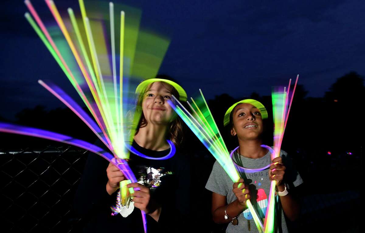 Residents Dorothy Den Dooven and Neera Arjunan, both 10, enjoy the Darien 2021 Fireworks Display at Darien High School Thursday, July 23, 2021, in Darien, Conn. Last year's display was cancelled due to the pandemic.