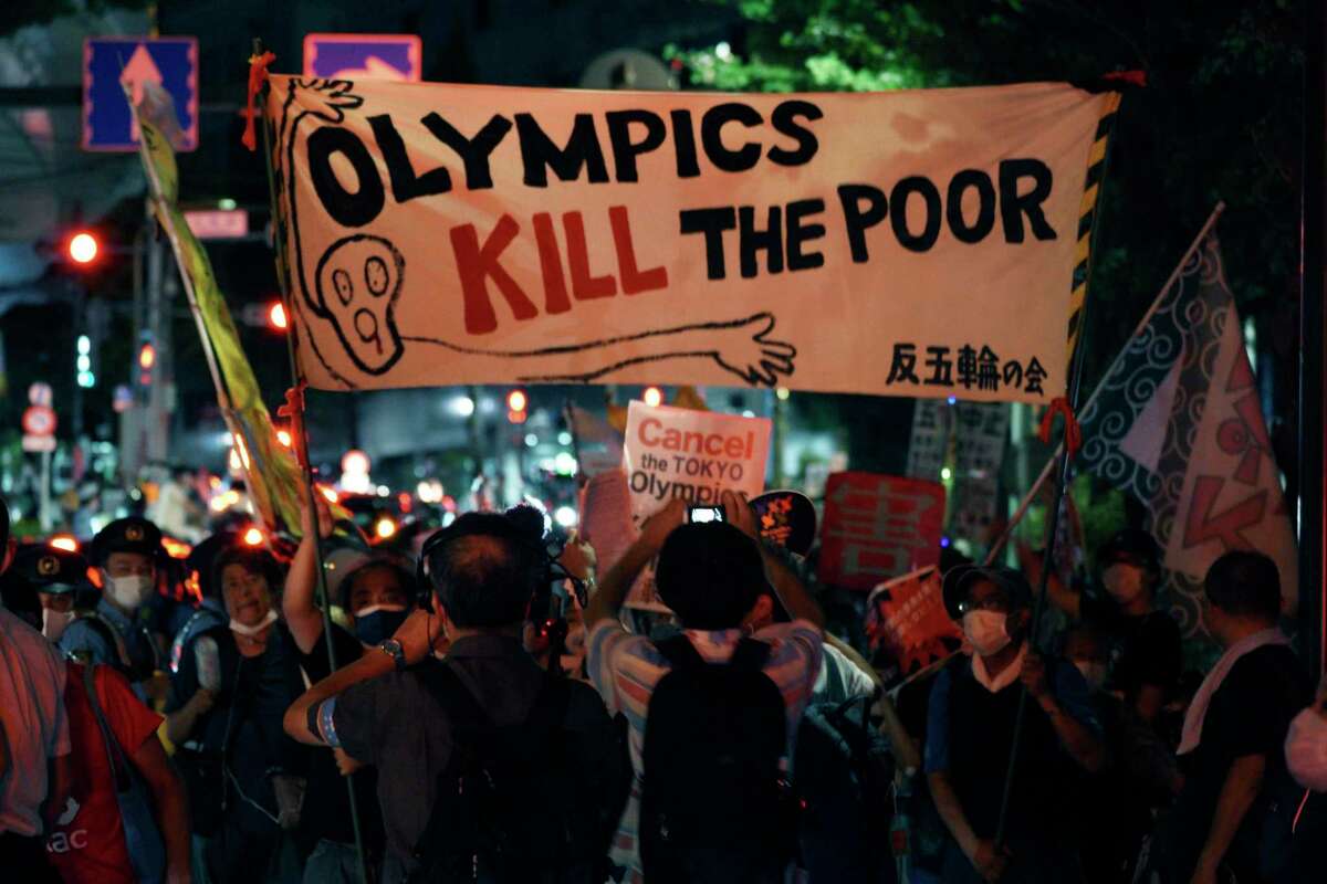 Anti-Olympic protestors demonstrate near the National Stadium in Tokyo, Japan where the opening ceremony of the Tokyo Olympics is taking place, Friday, July 23, 2021. (AP Photo/Kantaro Komiya)