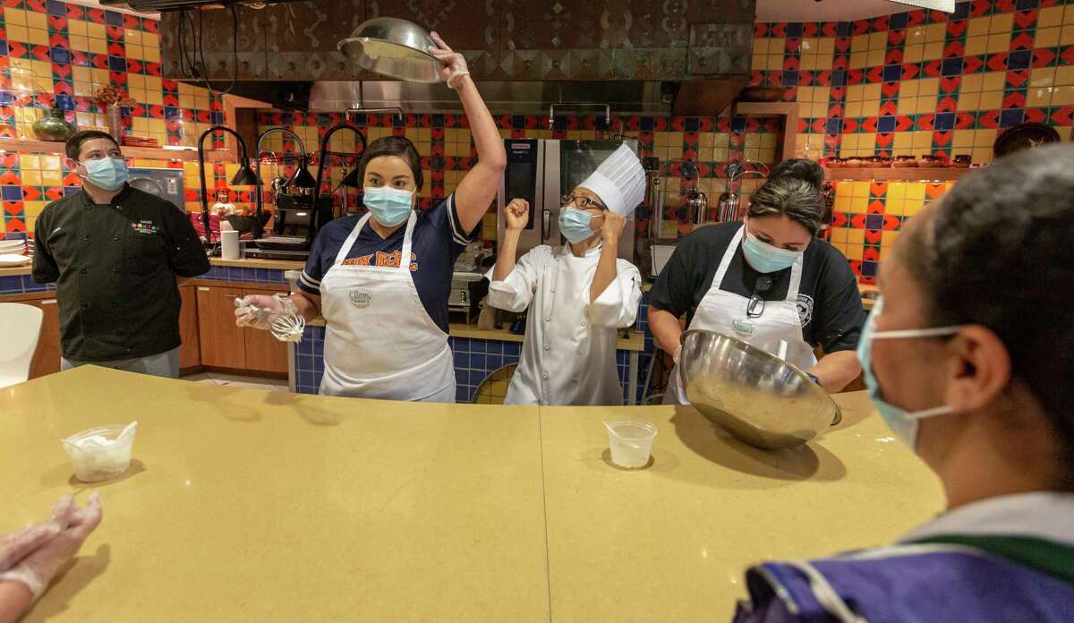 Disney Maldonado holds freshly whipped cream over her head Wednesday, July 21, 2021, as Culinary Institute of America faculty chef Uyen Pham, center, cheers during a contest to see who can make whipped cream the fastest. Maldonado, a San Antonio Independent School District cook, was at the CIA for a day-long training program designed to help the food services employees to develop their kitchen organization abilities and their food preparation and knife skills among other things.