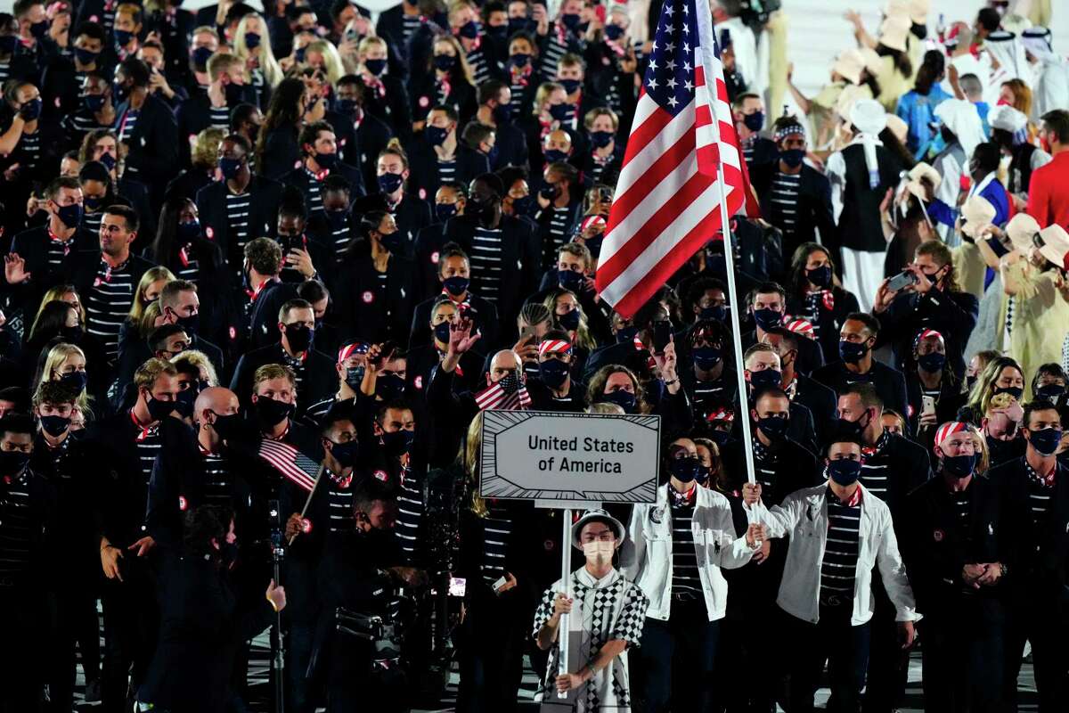 Athletes from the United States, including Sue Bird and Eddy Alvarez carrying their nations flag, take part in opening ceremonies at the Tokyo Olympics in Tokyo, Friday, July 23, 2021. (Frank Gunn/The Canadian Press via AP)