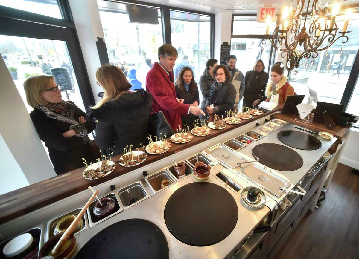 Visitors sample food at Crepes Choupette, a kiosk-like eatery on the Broadway Island at the Broadway Shopping District in New Haven after ribbon cutting in 2018 that officially opened the new business.