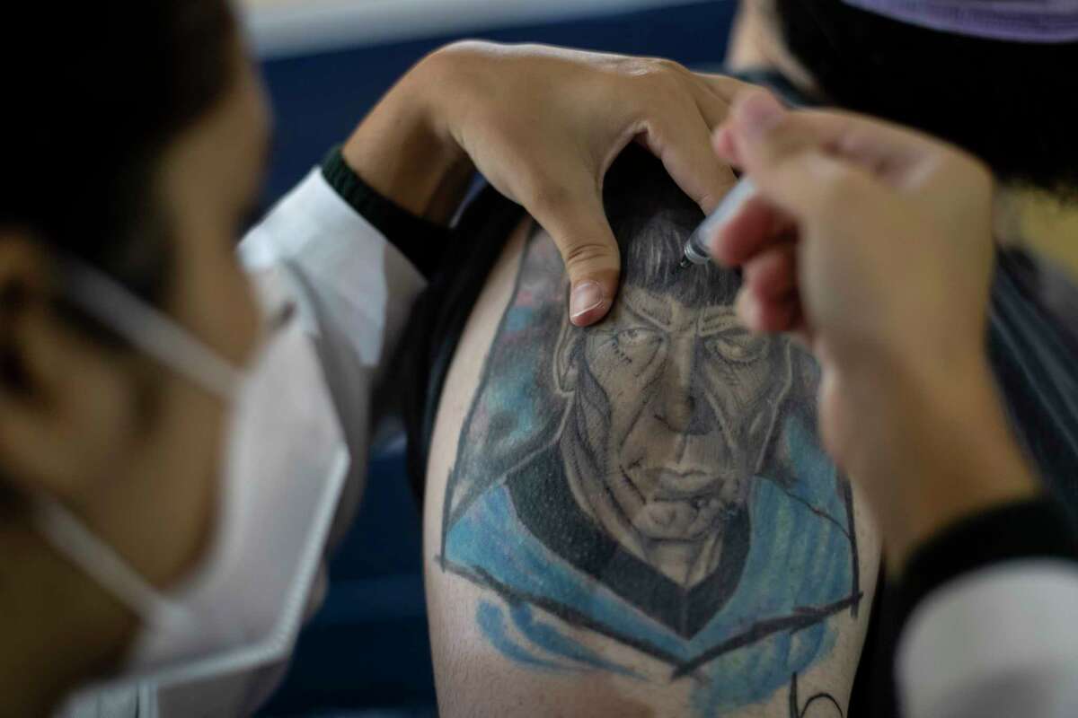 A man gets a shot of the AstraZeneca vaccine for COVID-19 in his arm covered by a tattoo of Star Trek's Spock character during a vaccination campaign for people over age 35 in Rio de Janeiro, Brazil, Friday, July 23, 2021. (AP Photo/Bruna Prado)