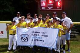 Simsbury players celebrate with the championship banner after winning the Connecticut Little League Section 2 title on Friday night.