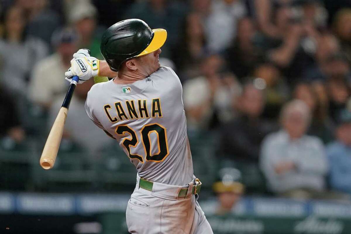 Oakland Athletics' Mark Canha strikes out with a foul tip to end the top of the sixth inning with the bases loaded during the team's baseball game against the Seattle Mariners, Thursday, July 22, 2021, in Seattle. (AP Photo/Ted S. Warren)