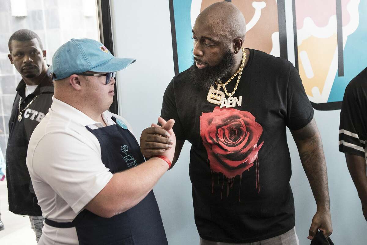 Trey Brandt, left, shakes hands with Trae the Truth during the grand opening of Howdy Homemade Ice Cream Thursday, July 22, 2021 in Katy. Hundreds of people flocked to the new ice cream franchise, owned and run by Houston rap artist, activist and philanthropist Trae tha Truth and his business partner Roderick Batson. The shop's mission is not just to serve up hand scooped ice cream but to also give employment opportunities to adults with special needs.