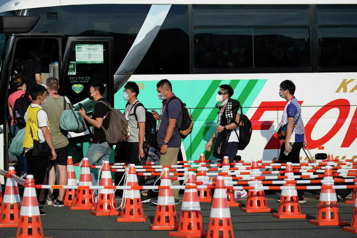 A maze of cones lead people onto a bus at the main transport hub at the 2020 Summer Olympics in Tokyo. Getting to and from events is often a confusing endeavor.