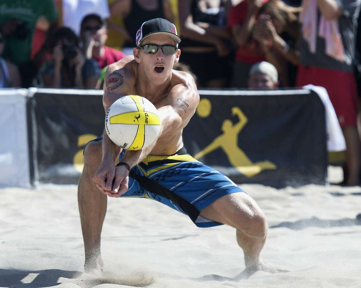 FILE - In this Sept. 21, 2014, file photo, Tri Bourne makes a dig as he and John Hyden played Casey Patterson and Jake Gibb during the AVP Championships beach volleyball match at Huntington Beach, Calif. American beach volleyball player Taylor Crabb is out of the Olympics after several positive COVID-19 tests, and Bourne will take his place as the partner of four-time Olympian Jake Gibb when the competition begins at Tokyo’s Shiokaze Park this weekend. (Kyusung Gong/The Orange County Register, File)