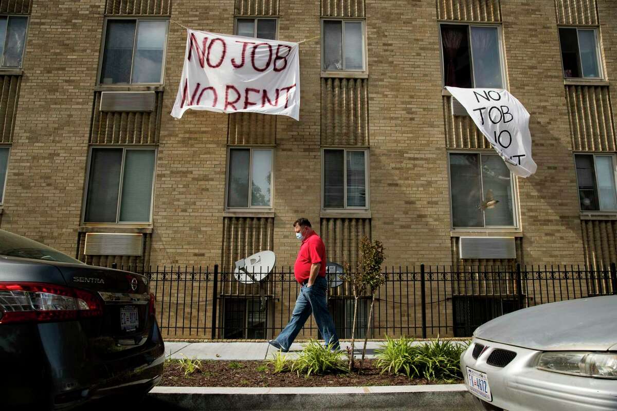 Signs that read “No Job No Rent” hang from the windows of an apartment building in Northwest Washington in May 2020. Renters are nearing the end of their financial rope as the assistance and protections given to them during the pandemic run their course. About 30 percent of renters polled by the U.S. Census say they have no confidence or slight confidence in their ability to pay rent next month.
