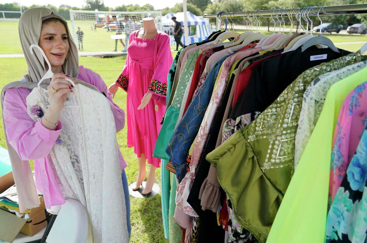 Shams Albayati displays clothing at the Embrohouse booth featuring designs by her and her sister, Sally Albayati, during the Eid Carnival at the Muslim American Society Katy Center, 1800 Baker Rd., Saturday, July 24, 2021 in Houston.