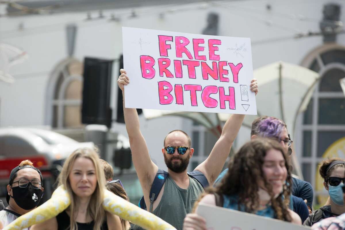 Tom Hood holds up a sign at a Free Britney rally on Market and Castro Streets in San Francisco on July 25, 2021.  The Free Britney Movement seeks to end Britney Spears Conservatories and raise awareness of Conservatory abuse.