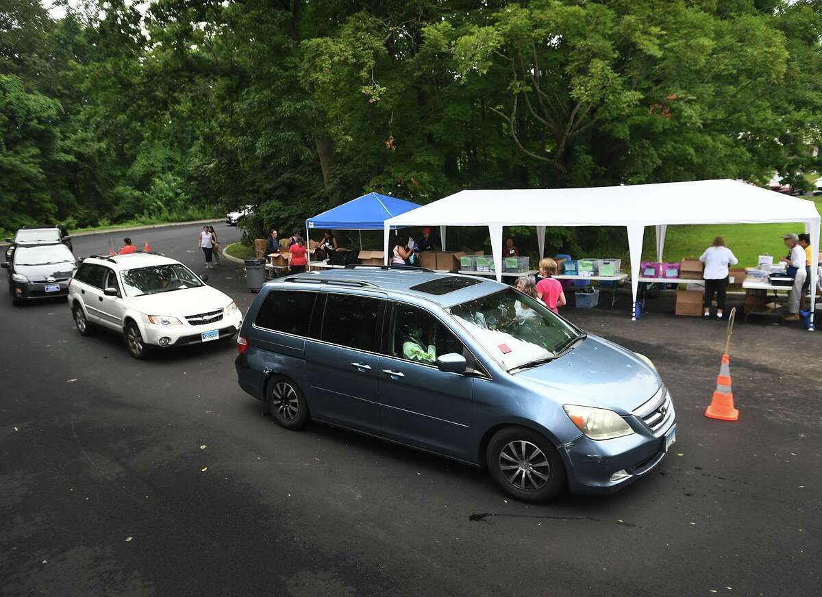 Cars are lined up during the annual back-to-school shop drive-thru distribution at Davenport Ridge Elementary School in Stamford, Connecticut on Sunday, July 25, 2021.