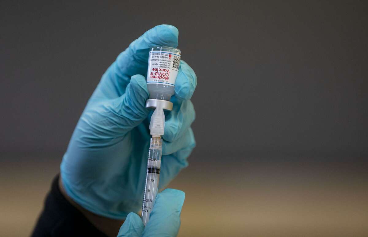 A syringe of the Moderna COVID-19 vaccine is prepared Feb. 14, 2021, at Steinmetz High School in Chicago.