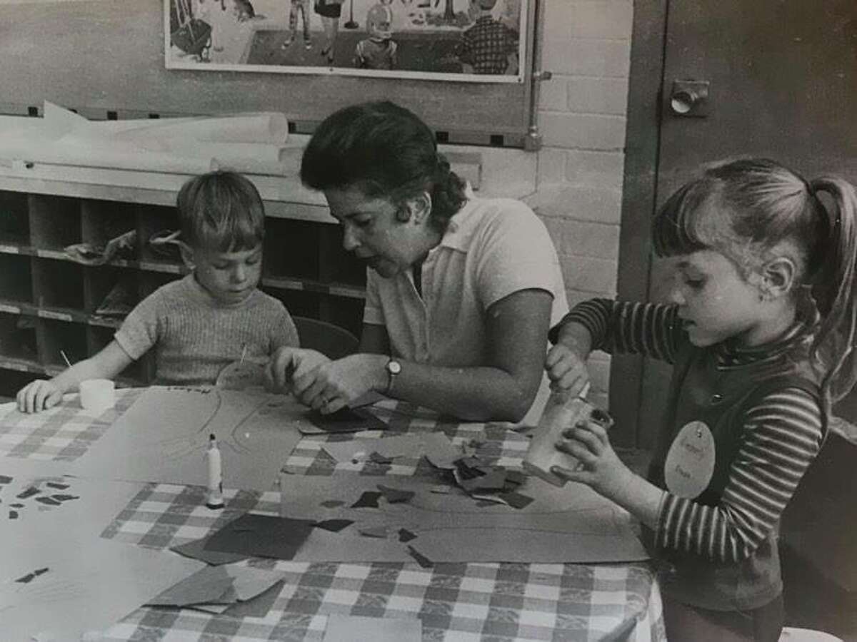 Mary Lou Pease helps Michael Fath and Kimberly Kruse make pictures from bits of paper. October 1973
