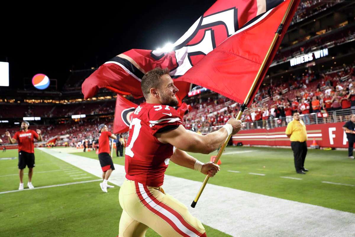 2019年10月7日星期一，旧金山49人队在加州圣克拉拉李维斯体育场举行的NFL比赛中以31-3击败克利夫兰布朗队后，尼克·博萨举着球队旗帜庆祝。