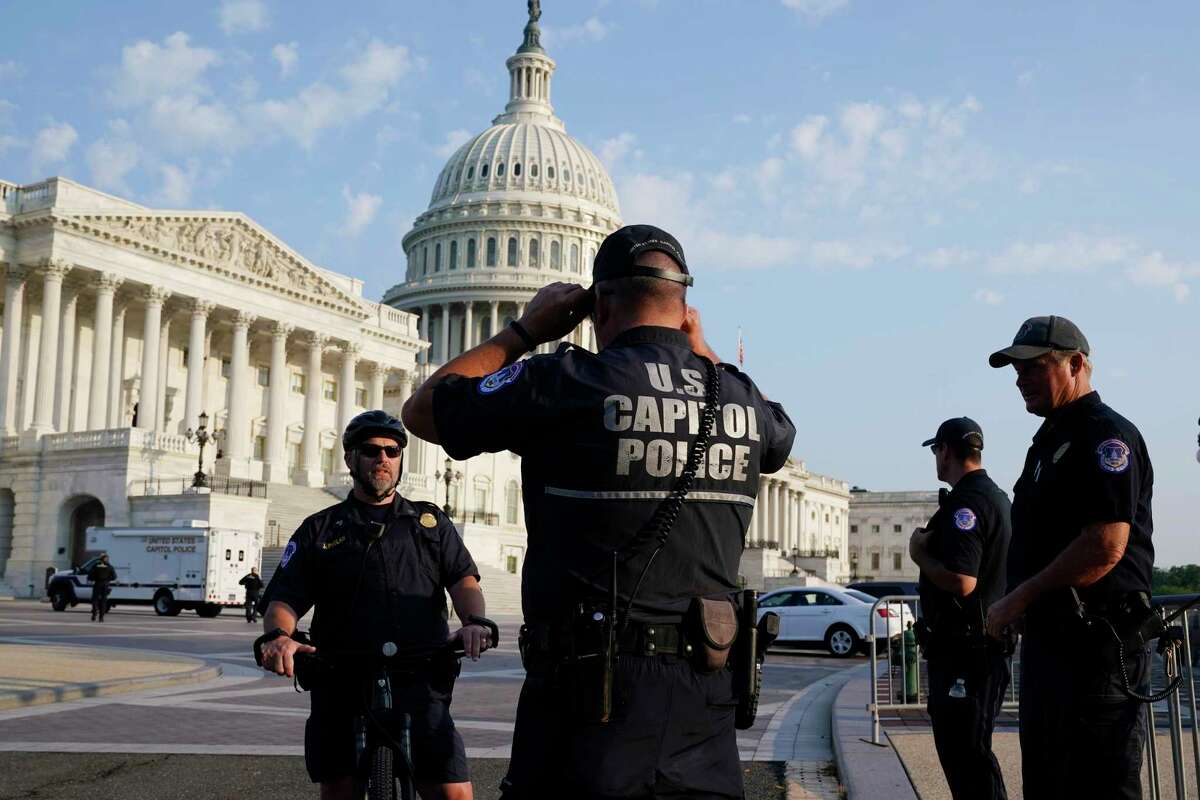 The U.S. Capitol is seen in Washington, early Tuesday, July 27, 2021, as U.S. Capitol Police watch the perimeter. Democrats are launching their investigation into the Jan. 6 Capitol insurrection. They're beginning with a focus on the law enforcement officers who were attacked and beaten as the rioters broke into the building. It's an effort to put a human face on the violence of the day. The police officers who are testifying Tuesday endured some of the worst of the brutality. The panel's first hearing comes as partisan tensions have only worsened since the insurrection. Many Republicans have played down or outright denied the violence that occurred and denounced the Democratic-led investigation as politically motivated.