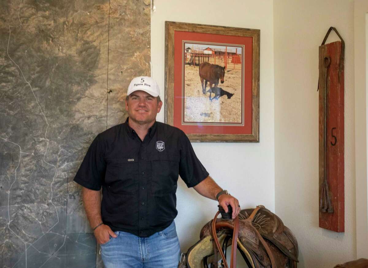 Fifth-generation Midlander John C. Scharbauer the owner of Scharbauer Ranches, The Midland Meat Co. and The Half Acre poses beside his map of the Amarillo ranch, a photo of his horse Smootch and one of the ranch’s cattle branding irons “5” for a portrait July 21 in his office at 1108 Washita. Jacy Lewis/Reporter-Telegram