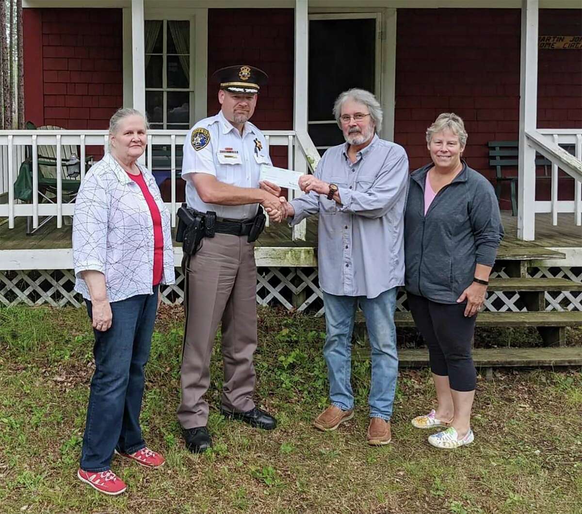 Lake County Sheriff Rich Martin presents a check for $1,000 to the Martin Johnson Heritage Museum in Irons. (Courtesy/Lake County Sheriff's Office)