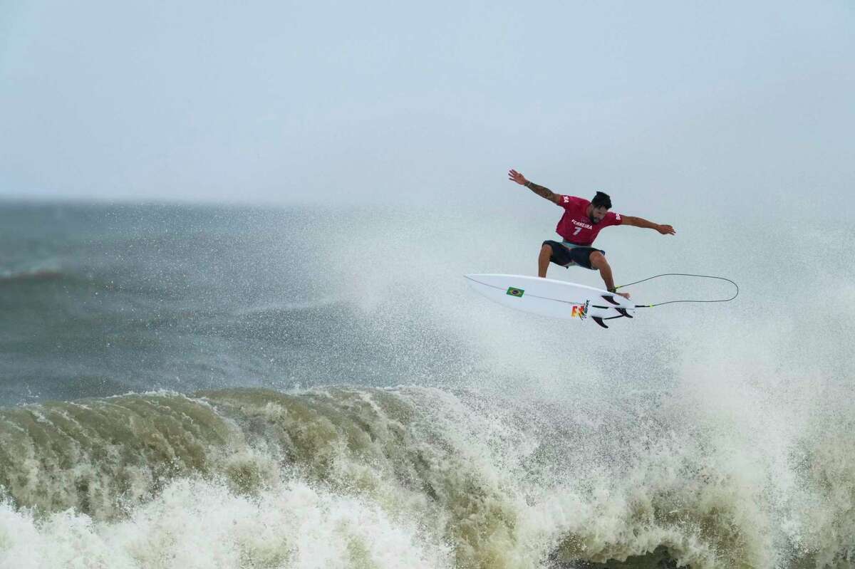 Brazil's Italo Ferreira goes to the air on a wave during the semifinals of the men's surfing competition at the 2020 Summer Olympics, Tuesday, July 27, 2021, at Tsurigasaki beach in Ichinomiya, Japan. Ferreira won the gold medal. (AP Photo/Francisco Seco)