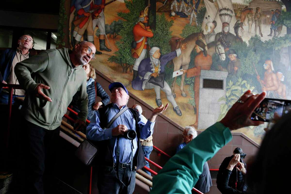 Brian Freeman (l to r) of San Francisco and Jim Mayer of Oakland discuss the 1936 mural depicting the life of George Washington by San Francisco artist Victor Arnautoff at George Washington High School during a public viewing on Thursday, August 1, 2019 in San Francisco, Calif.