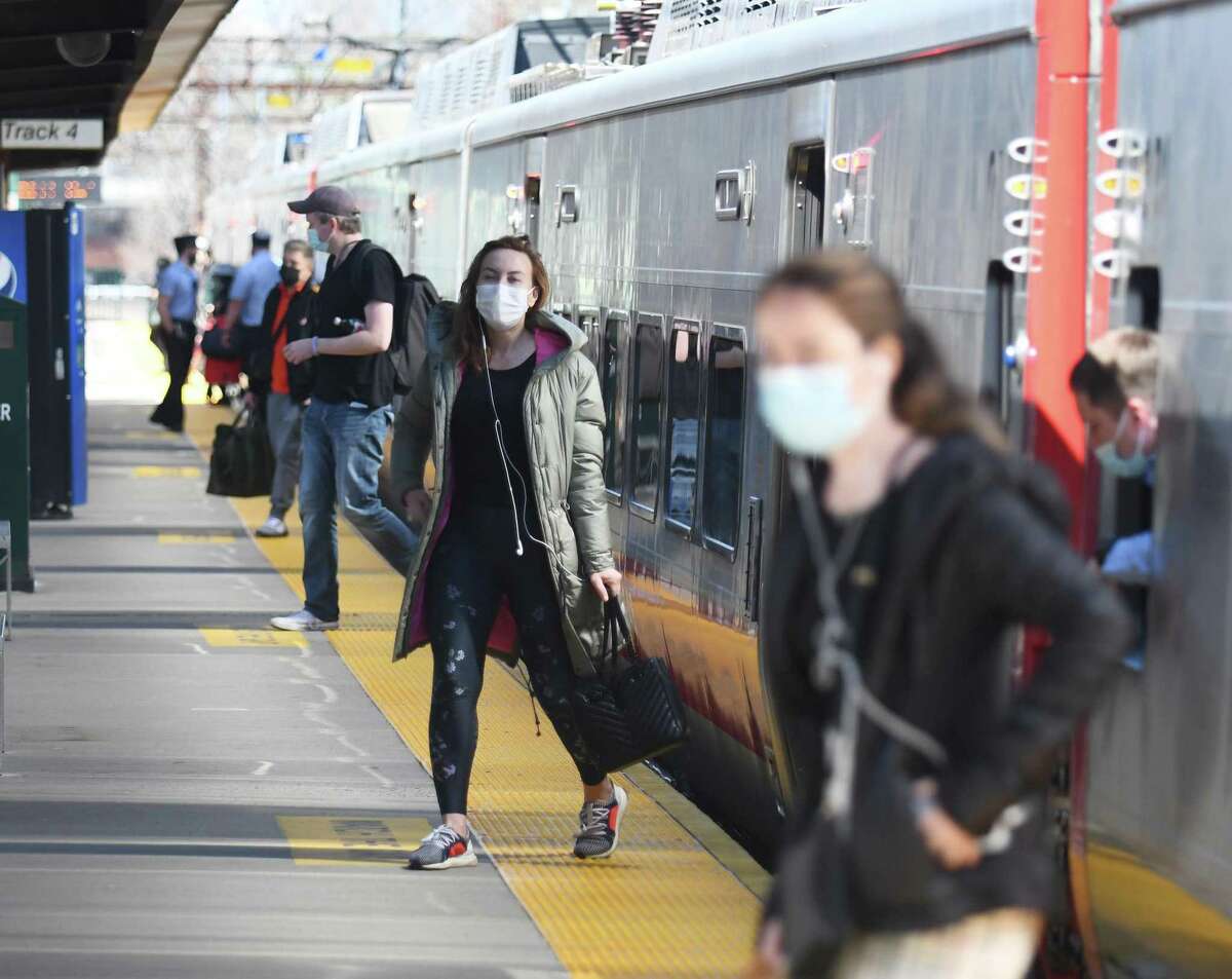 Passengers disembark from a northbound Metro-North train at the central Greenwich train station in Greenwich, Conn. Wednesday, April 7, 2021.