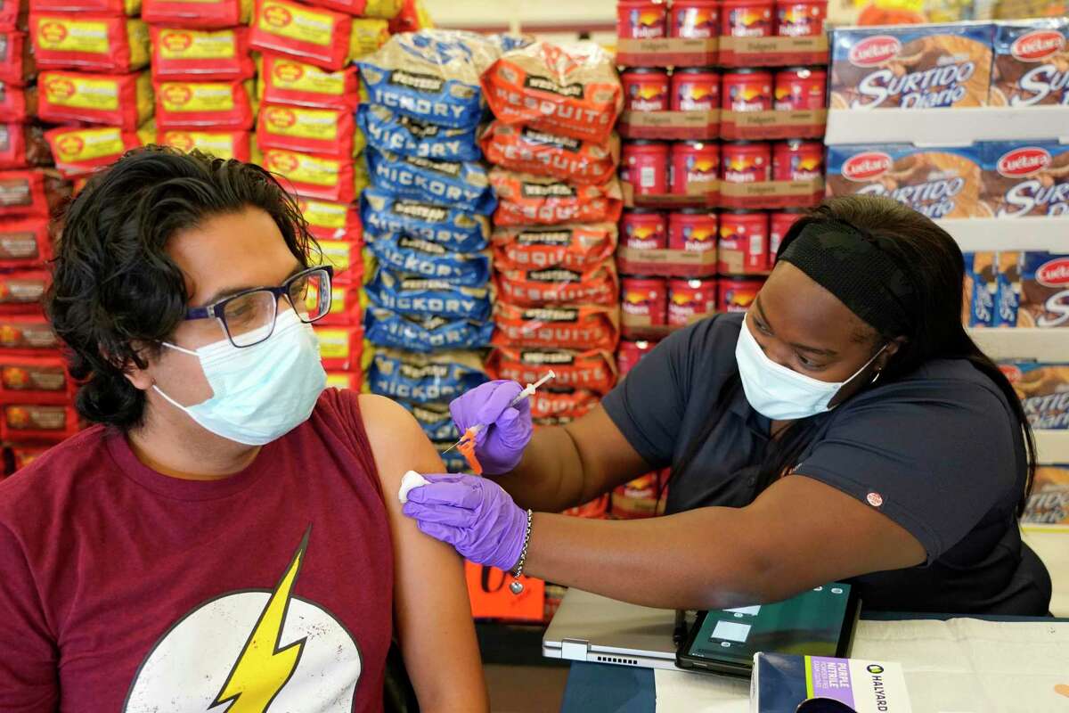 Ruben Salazar, left, receives a Pfizer vaccination from Kiosha Martin, LVN with Houston Health Department, during an event held at Food Town, 5367 Antoine Dr., Tuesday, July 27, 2021 in Houston.