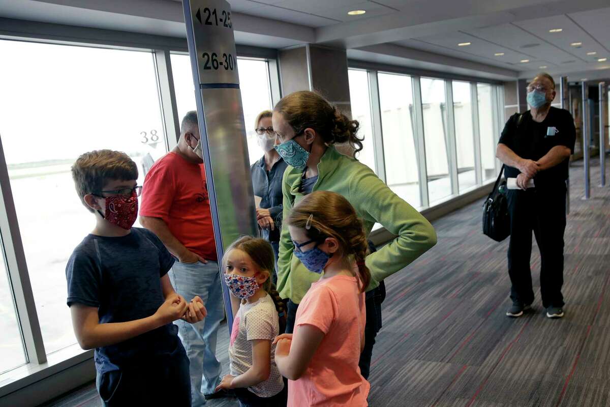FILE - People wearing masks wait to board a Southwest Airlines flight at Kansas City International airport in Kansas City, Mo., in this May 24, 2020, file photo. Governments and businesses are scrambling to change course following new federal guidance calling for the return of mask wearing in virus hot spots amid a dramatic spike in COVID-19 cases and hospitalizations nationwide. Nevada and Kansas City were among the locations that moved swiftly to re-impose indoor mask mandates following Tuesday’s, July 27, 2021, announcement from the Centers for Disease Control and Prevention.