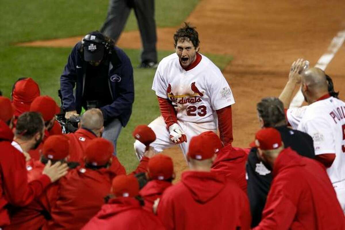 David Freese of the Cardinals is met by teammates after his game-winning home run in Game 6 of the 2011 World Series against the Texas Rangers.
