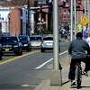 A bicyclists rides on the sidewalk along Route 136 at Water Street Tuesday, April 6, 2021, in Norwalk, Conn.