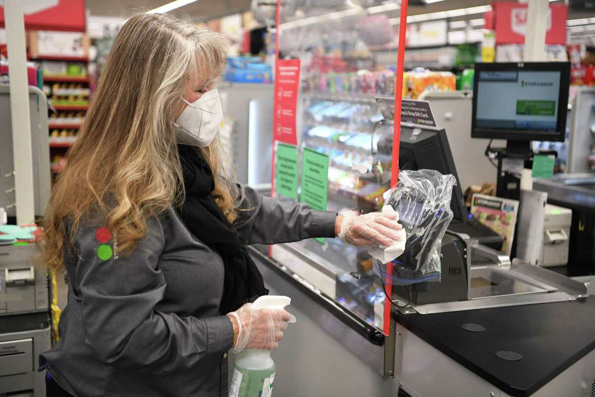 A Stop & Shop employee sanitizes a checkout line in April 2020 at a store in Connecticut.