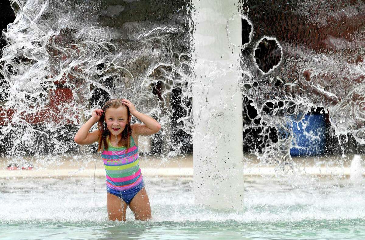 Amelia Cook gets doused in the fountain while cooling off at the Alice Keith Park pool Tuesday, which was the first day of the hottest weeks of summer, according to Space City Weather. Photo made Tuesday, July 27, 2021 Kim Brent/The Enterprise