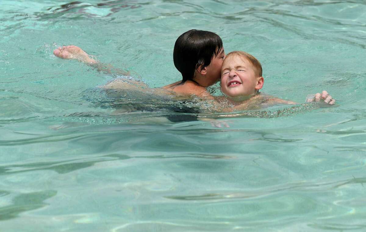 Hayden Robins (left) and neighbor friend Jackson Cook horse around while cooling off at the Alice Keith Park pool Tuesday, which was the first day of the hottest weeks of summer, according to Space City Weather. Photo made Tuesday, July 27, 2021 Kim Brent/The Enterprise